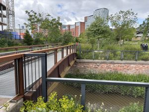 One of the bridges over the river incorporating one of the old beams from the old mill buildings